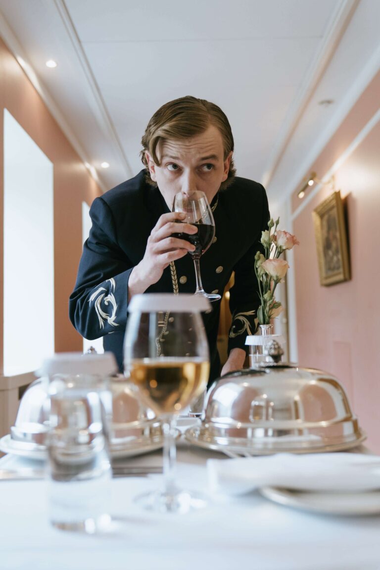 Camarero bebiendo vino a espaldas del cliente